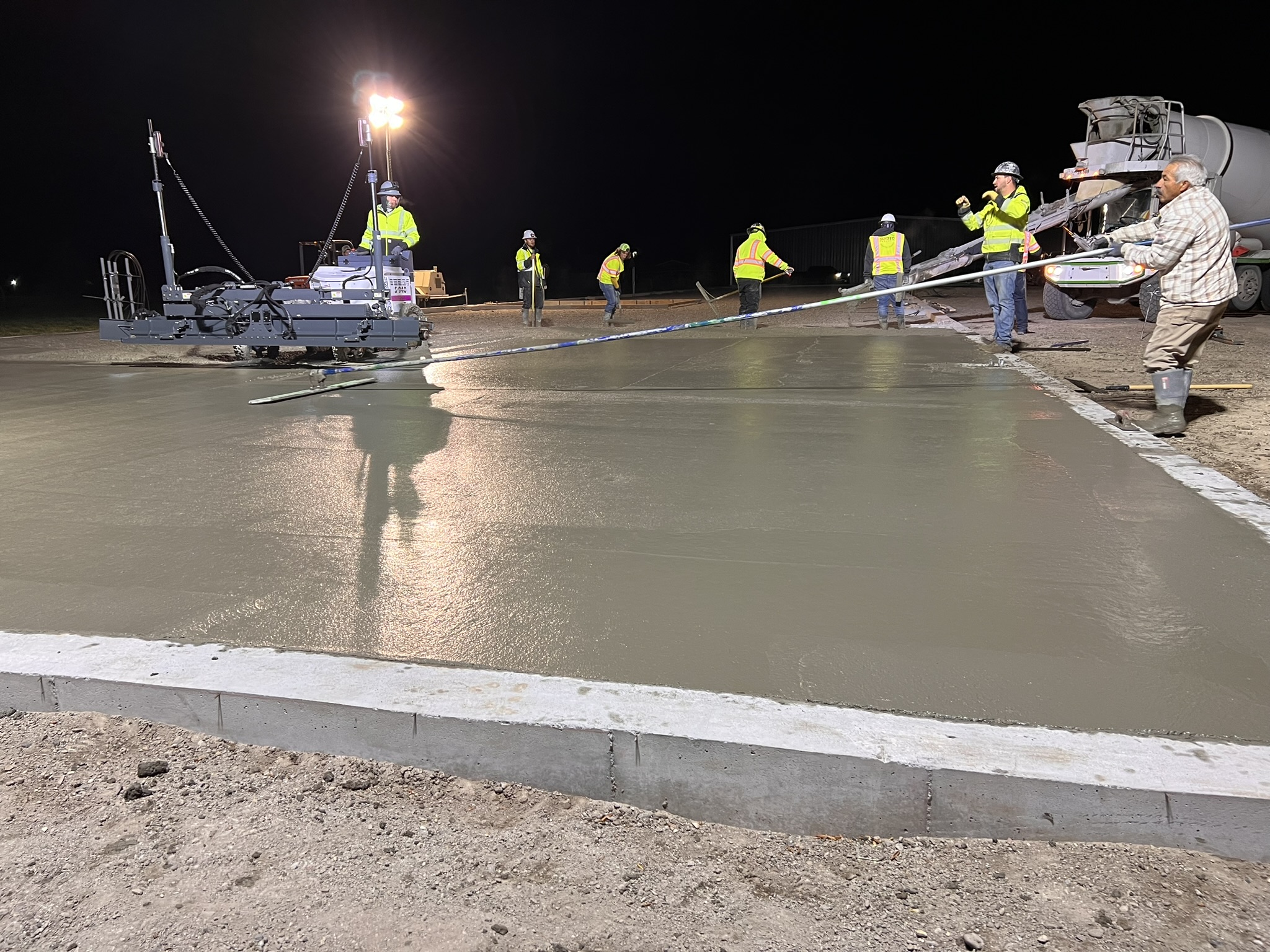 Concrete pour taking place at night under job lighting